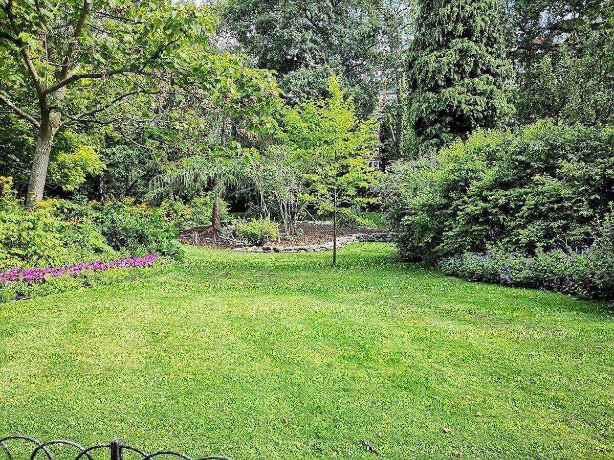 Garten mit Rasen und Pflanzen an einem Haus